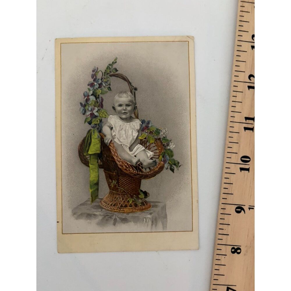 Vintage Chromolithograph cabinet caad of baby in wicker basket with flowers